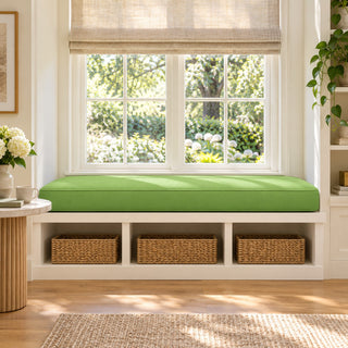 Custom green window seat cushion on a built-in window bench with woven storage baskets